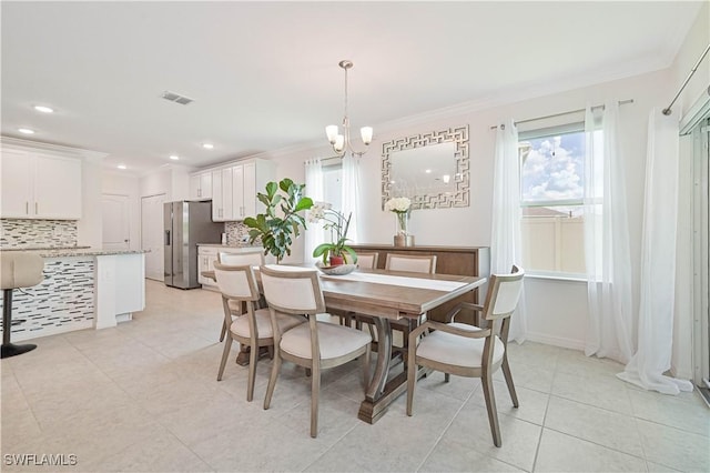 dining space featuring light tile patterned floors, crown molding, a wealth of natural light, and a chandelier