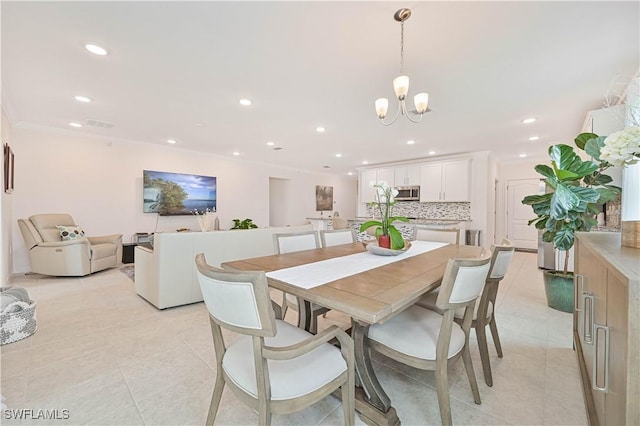 tiled dining space with an inviting chandelier and ornamental molding