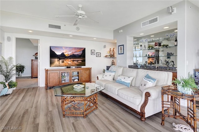 living room with bar, hardwood / wood-style flooring, and ceiling fan