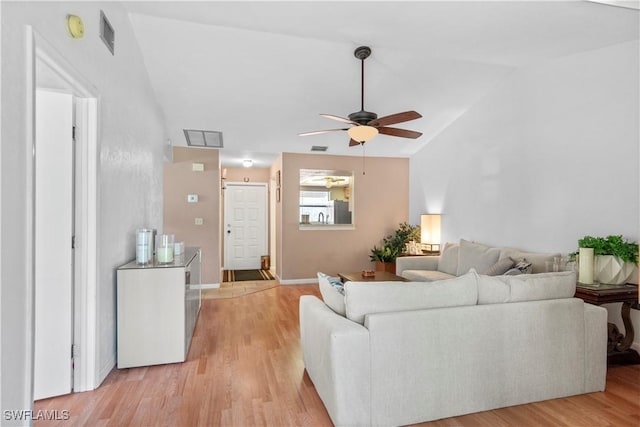 living room featuring vaulted ceiling, ceiling fan, and light wood-type flooring