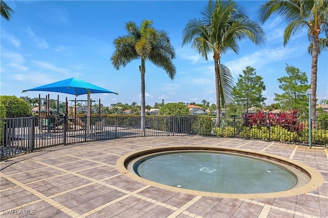 view of pool with playground community and fence