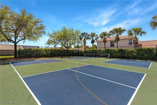 view of basketball court featuring a tennis court and fence