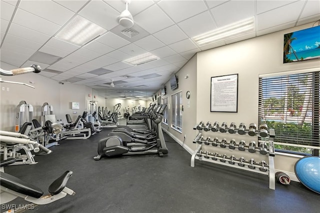 exercise room featuring a drop ceiling, visible vents, and baseboards