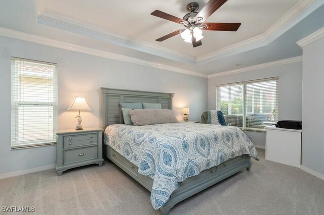 bedroom featuring ornamental molding, a tray ceiling, and light carpet