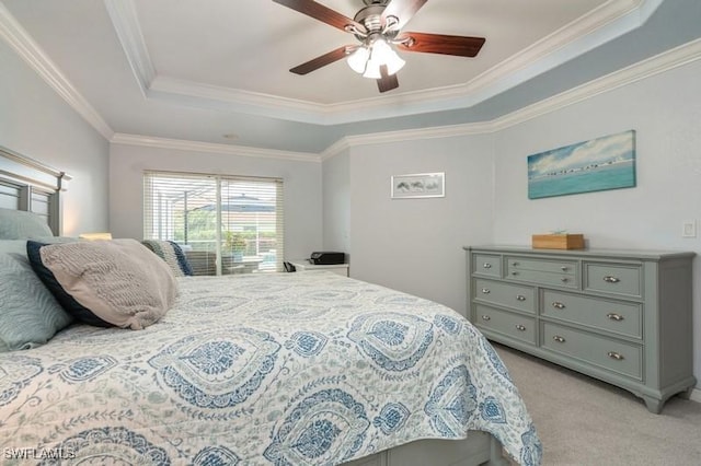 bedroom featuring light carpet, ceiling fan, a tray ceiling, and ornamental molding