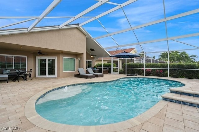 pool with a lanai, a patio area, and ceiling fan