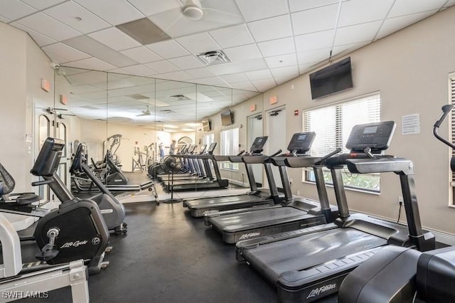 exercise room featuring baseboards, visible vents, and a drop ceiling