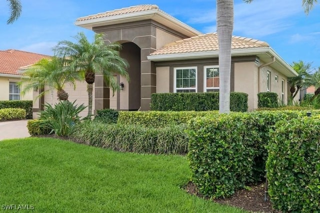 view of home's exterior featuring an attached garage, stucco siding, a tile roof, and a yard