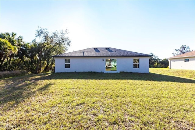 rear view of property featuring a yard