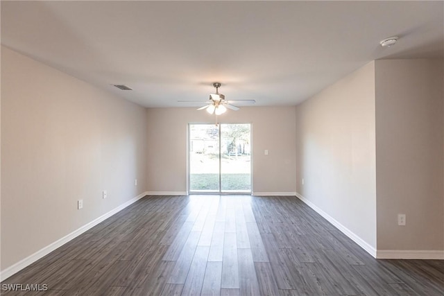 spare room with dark wood-type flooring and ceiling fan