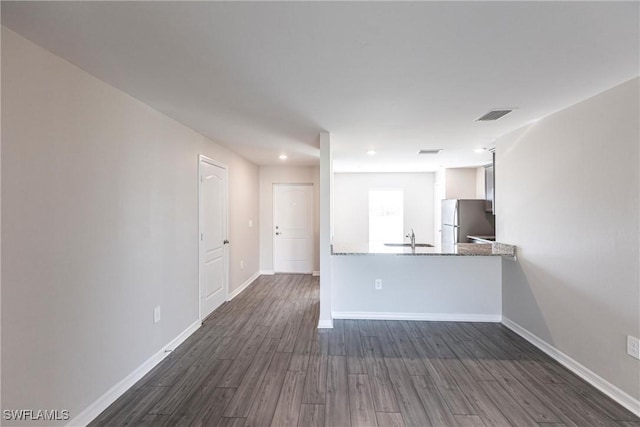 unfurnished living room featuring dark hardwood / wood-style flooring and sink