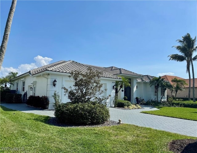 view of front of property with a garage and a front lawn