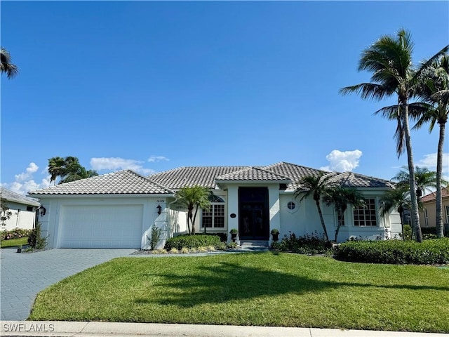 mediterranean / spanish-style home featuring a garage and a front yard