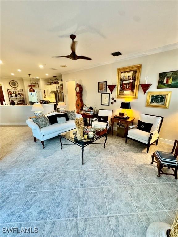 living room with ceiling fan, crown molding, and tile patterned flooring