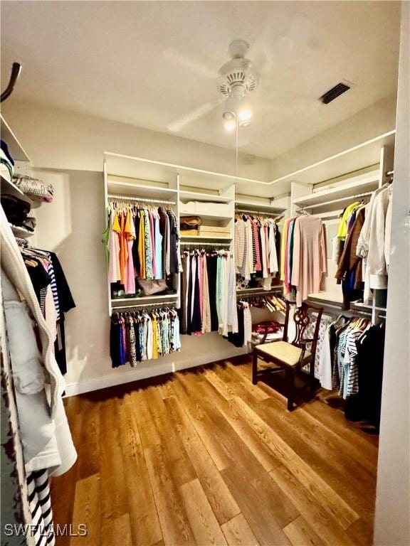 walk in closet with ceiling fan and wood-type flooring