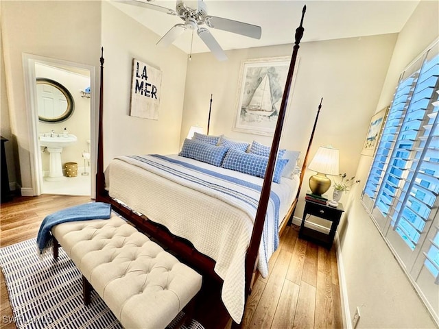 bedroom featuring sink, ensuite bathroom, hardwood / wood-style floors, and ceiling fan