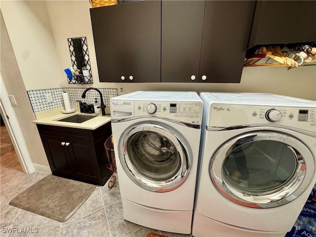 washroom with sink, cabinets, and independent washer and dryer