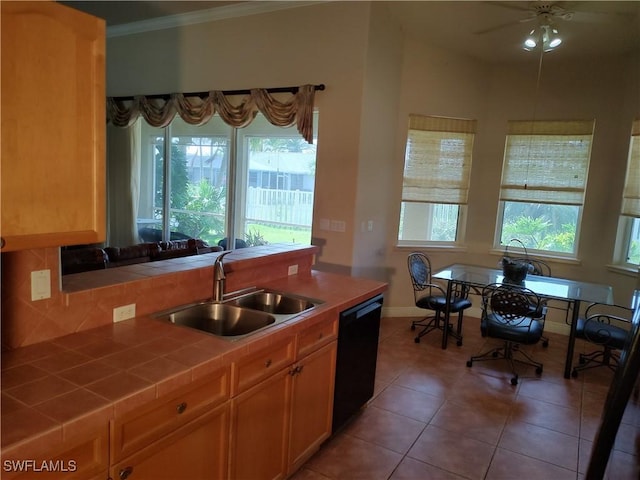 kitchen with black dishwasher, crown molding, tile countertops, a sink, and tile patterned floors