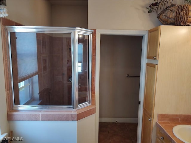 full bath with a sink, baseboards, and tile patterned floors