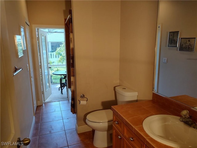 bathroom featuring tile patterned flooring, baseboards, vanity, and toilet