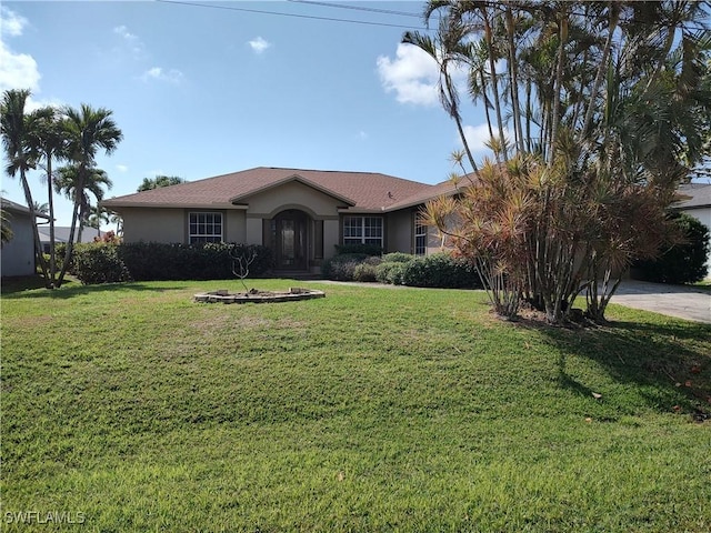 ranch-style house with stucco siding, an attached garage, and a front yard