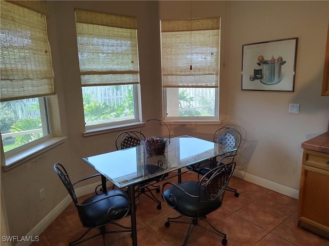 dining space featuring light tile patterned floors and baseboards