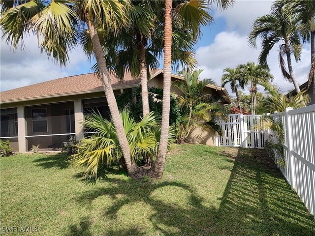 view of yard featuring a fenced backyard and a sunroom