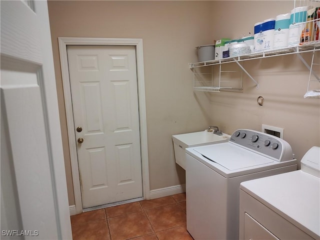 laundry area featuring a sink, laundry area, washing machine and dryer, and tile patterned flooring