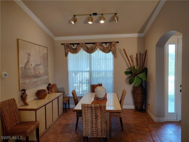 dining room with arched walkways, ornamental molding, and a wealth of natural light