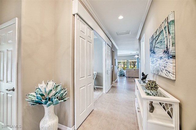 hall featuring light tile patterned floors and crown molding