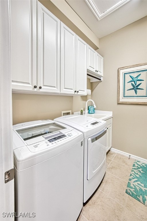 washroom featuring sink, washing machine and dryer, cabinets, and light tile patterned flooring