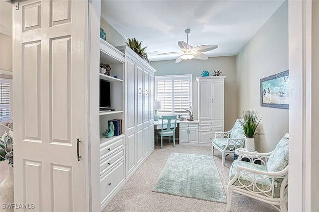 living area with ceiling fan and light carpet