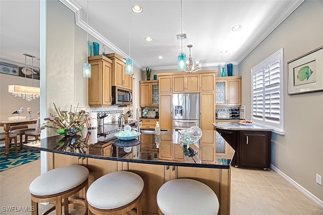 kitchen featuring a kitchen bar, crown molding, decorative light fixtures, appliances with stainless steel finishes, and a kitchen island