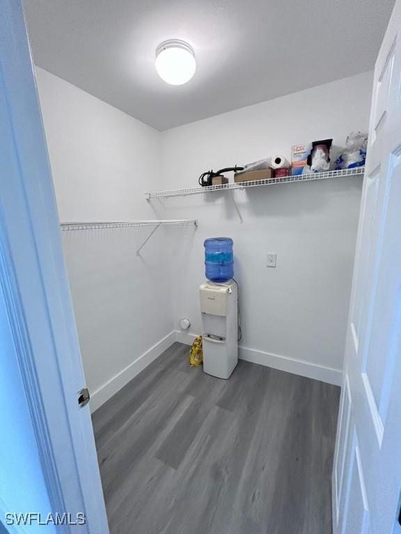 clothes washing area with dark wood-type flooring