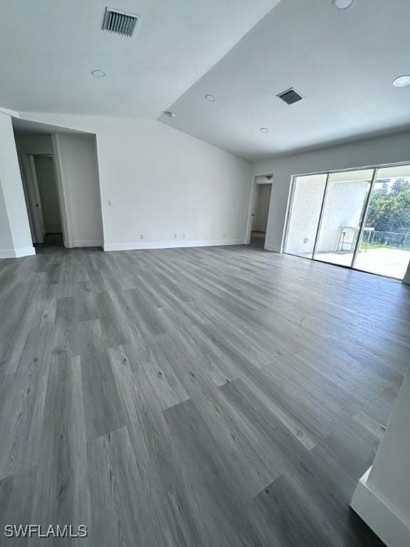 unfurnished room with wood-type flooring and vaulted ceiling