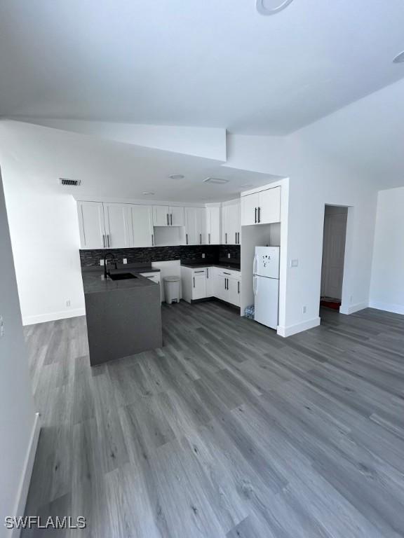 kitchen featuring backsplash, sink, white cabinets, and white refrigerator