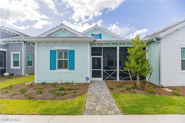 view of front of property with a front lawn and a sunroom