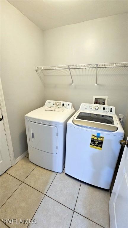 laundry area featuring light tile patterned floors and washer and dryer