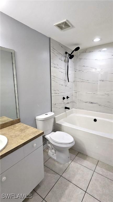 full bathroom with vanity, tiled shower / bath, tile patterned flooring, and toilet