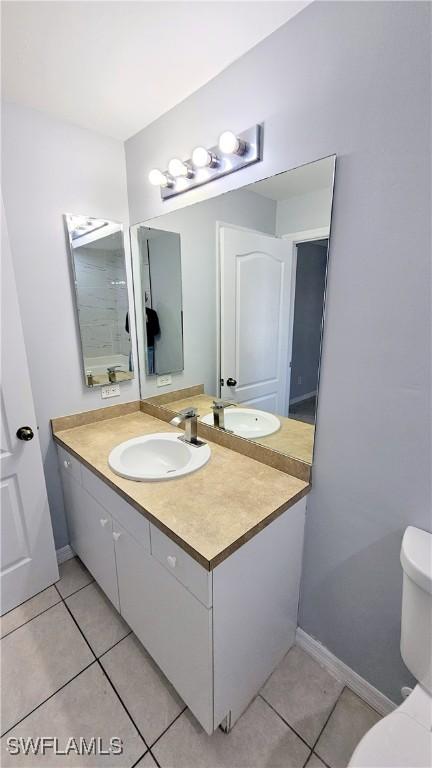 bathroom featuring tile patterned floors, toilet, and vanity