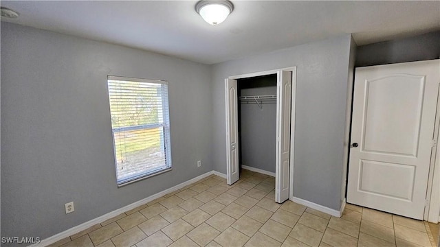 unfurnished bedroom with light tile patterned flooring and a closet