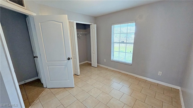 unfurnished bedroom with light tile patterned floors and a closet