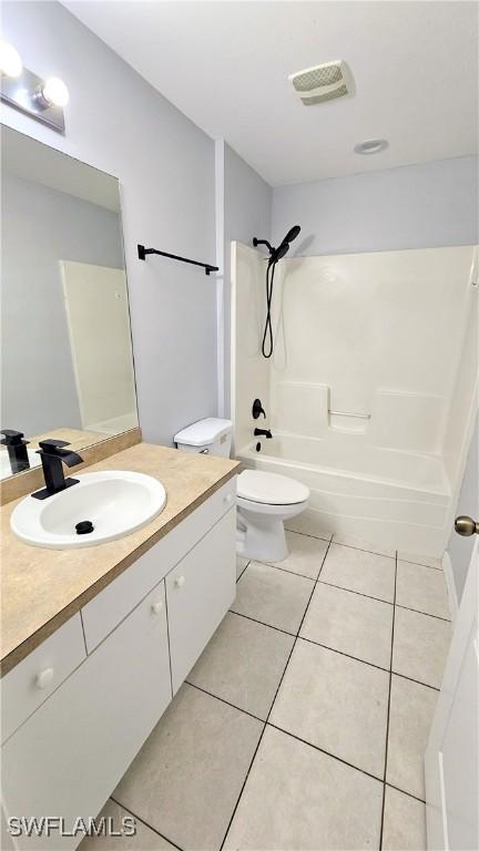 full bathroom with vanity, bathtub / shower combination, tile patterned floors, and toilet