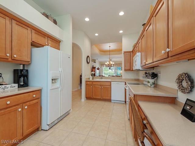 kitchen featuring light tile patterned floors, white appliances, sink, hanging light fixtures, and a raised ceiling