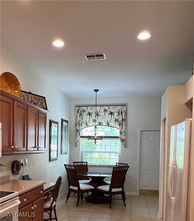 tiled dining space with a chandelier