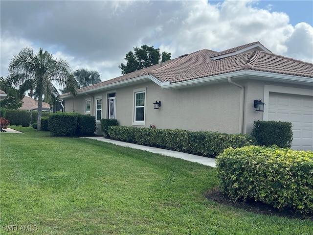 single story home featuring a garage and a front lawn