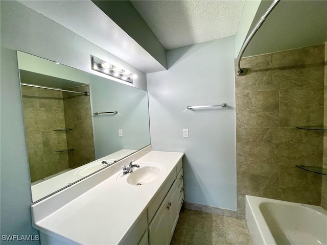 bathroom with washtub / shower combination, a textured ceiling, baseboards, and vanity