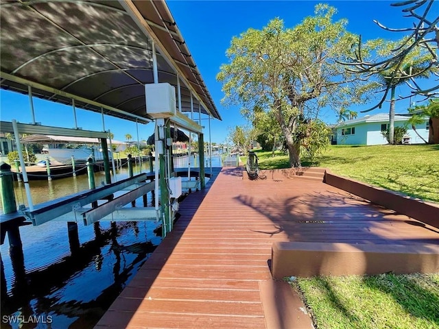 dock area with a water view, a lawn, and boat lift