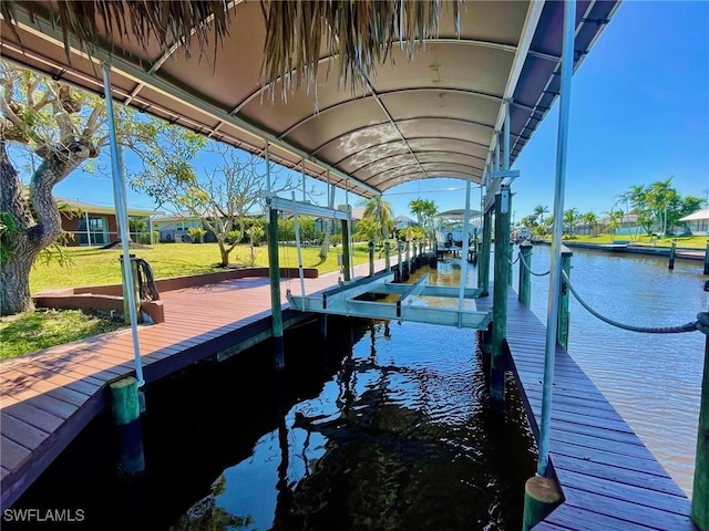 dock area with a water view and a lawn