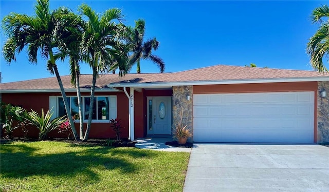 ranch-style home featuring a garage, a front yard, concrete driveway, and stucco siding